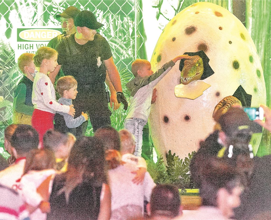 Die Kinder dürfen den aus dem Ei schlüpfenden Dino streicheln. Foto: Fotomoment