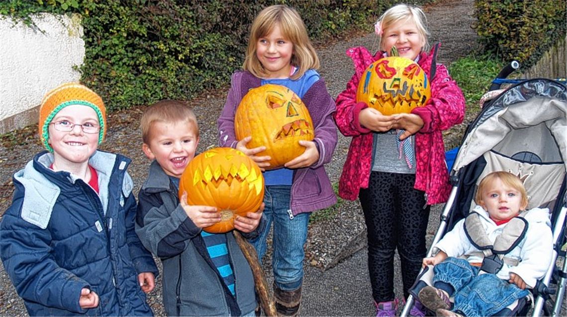 Die Kinder freuen sich über ihre Kürbisse.
