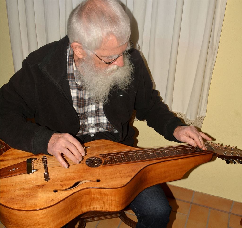 Die Lap-Steel-Gitarre wird im Sitzen gespielt und auf dem Schoß des Musikers platziert. Rechtes Bild: Unzählige Instrumente hat der Dürrmenzer Hansjörg Michl gerichtet. Fotos: Stahlfeld