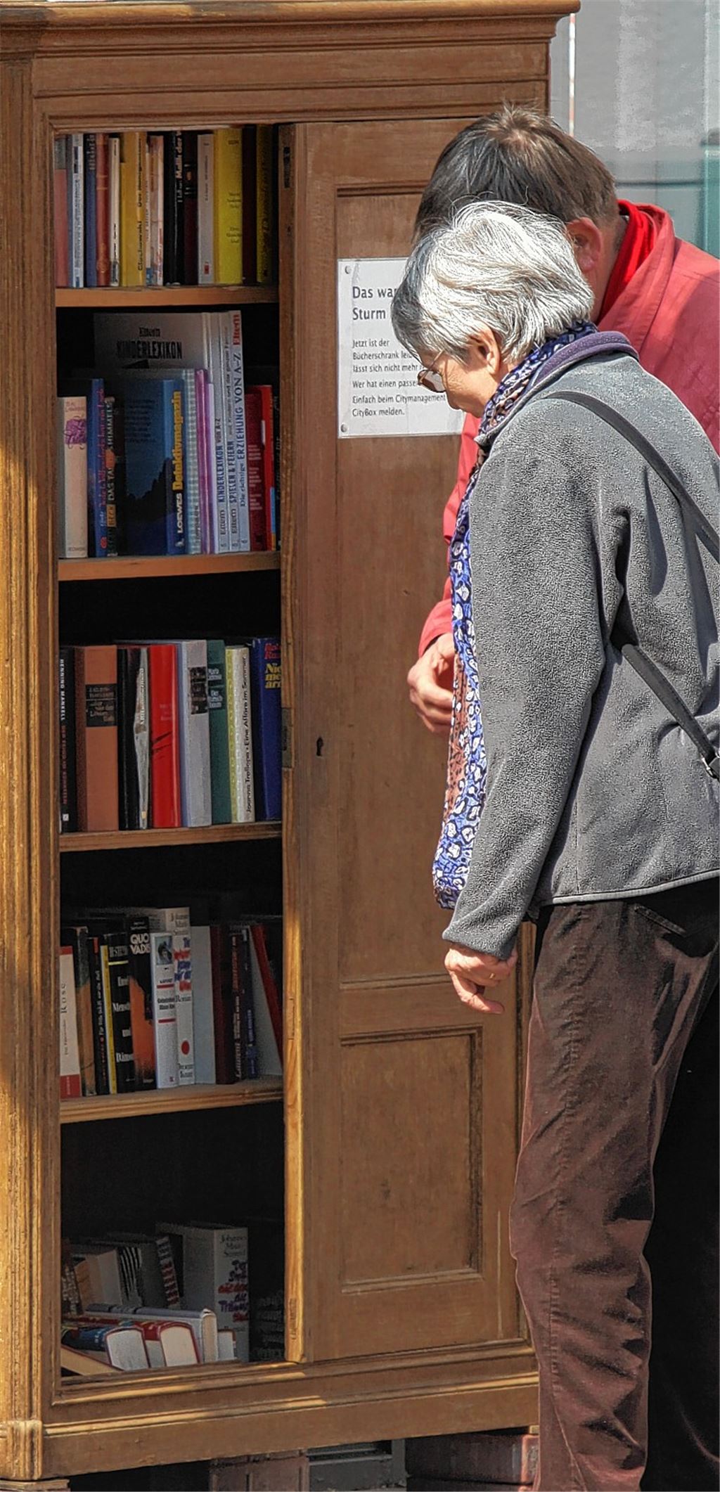 Die Lomersheimer Gislinde und Christoph Köhler stöbern im Bücherschrank, dessen linke Tür von Sturmtief Niklas abgerissen wurde.