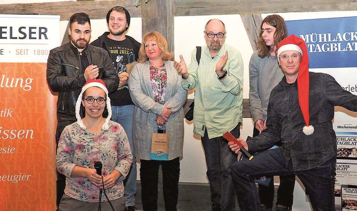 Die Moderatoren Ramona Deeg und Achim Dürr (mit Nikolausmützen) freuen sich mit den Teilnehmerinnen und Teilnehmern über einen gelungenen (Vor-)Weihnachtsslam. Auf dem Bild fehlt Slammerin Jana Schick. Foto: Müller