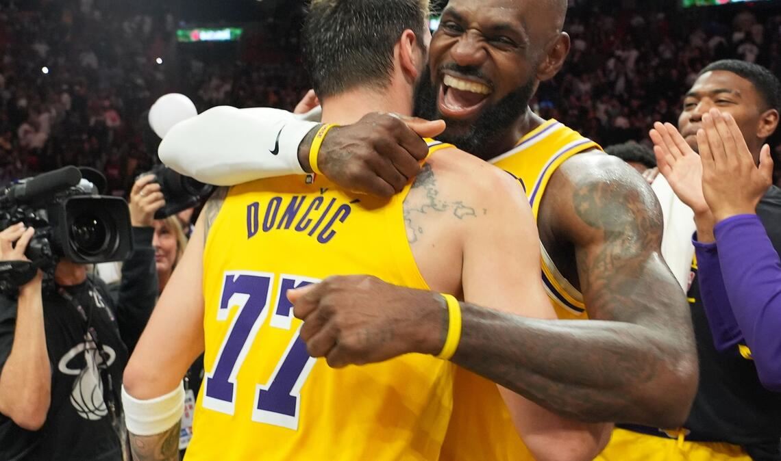 Die NBA-Stars Luka Doncic (l) und LeBron James von den Los Angeles Lakers umarmen sich nach ihrem Sieg gegen die Miami Heat.