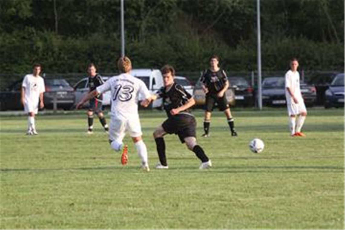 Die Ötisheimer Spieler (in Schwarz) werden vom eigenen Spielfeld ausgetrickst. Auf dem holprigen und knochenharten Untergrund springt der Ball oft anders als gedacht.  Foto: Eigner