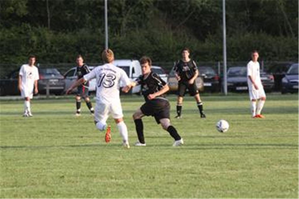 Die Ötisheimer Spieler (in Schwarz) werden vom eigenen Spielfeld ausgetrickst. Auf dem holprigen und knochenharten Untergrund springt der Ball oft anders als gedacht.  Foto: Eigner
