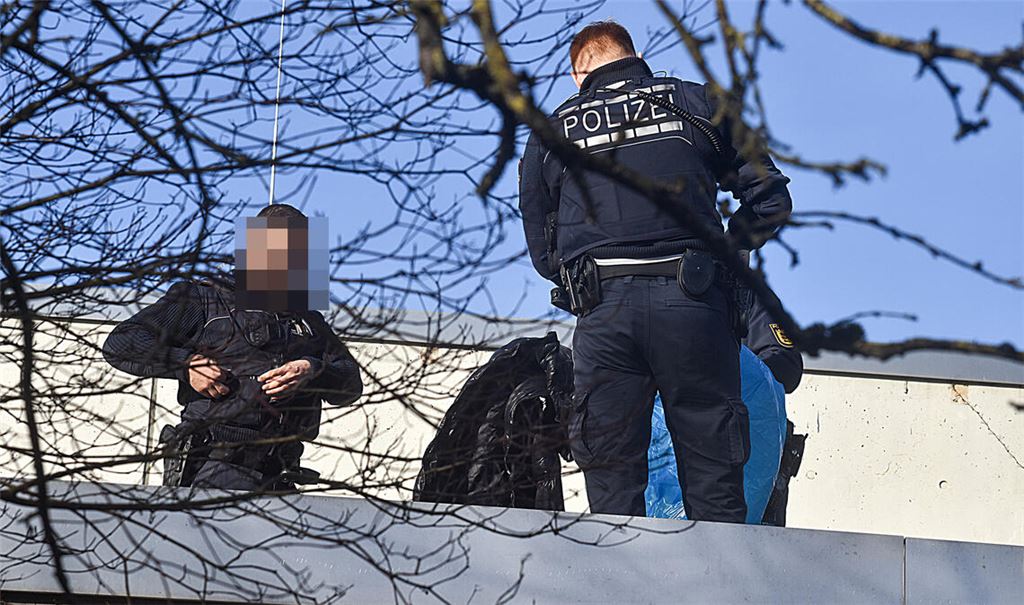 Die Polizei stellt nach dem Angriff unter anderem auf einem Dach der Fritz-Erler-Schule Objekte sicher. Foto: Myroshnichenko