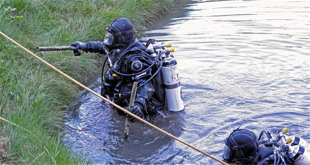 Die Polizeitaucher fischen eine verdächtige Metallstange aus dem Schlamm. Womöglich hat der Pferdeschänder mit ihr ein Tier zu Tode gequält. Fotos: Goertz