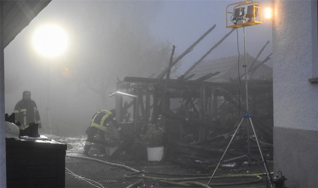 Die Scheune ist nicht mehr zu retten und wird nach dem Brand abgerissen. Dabei kommt schweres Gerät des Technischen Hilfswerks zum Einsatz. Foto: Myroshnichenko