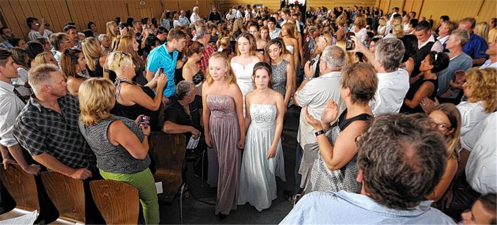 Die Schulabgänger laufen unter dem Beifall der Angehörigen in die Festhalle ein. Foto: Fotomoment