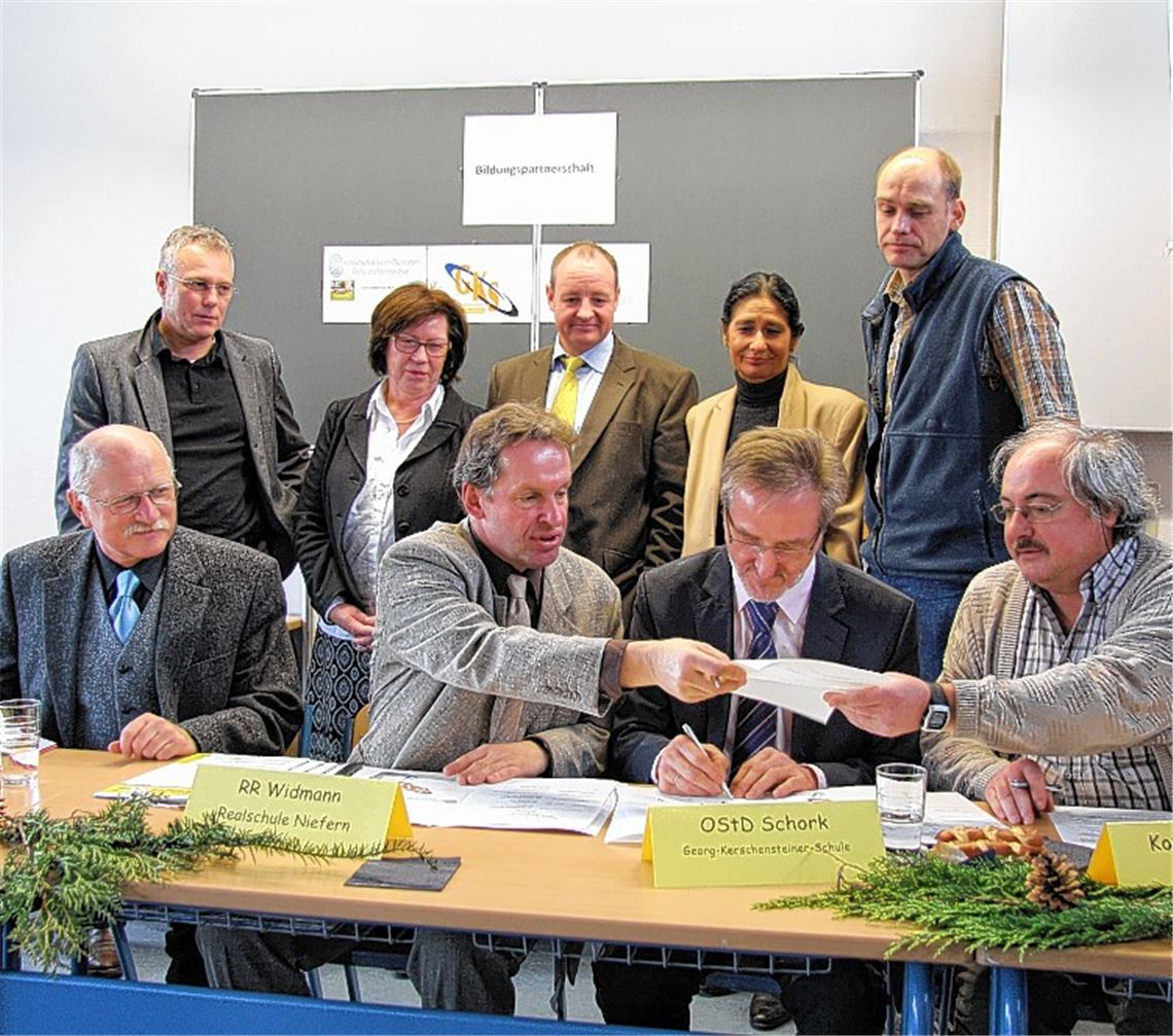 Die Schulleiter Markus Widmann und Rainer Schork (Mitte) unterzeichnen die Vereinbarung für eine Bildungspartnerschaft.