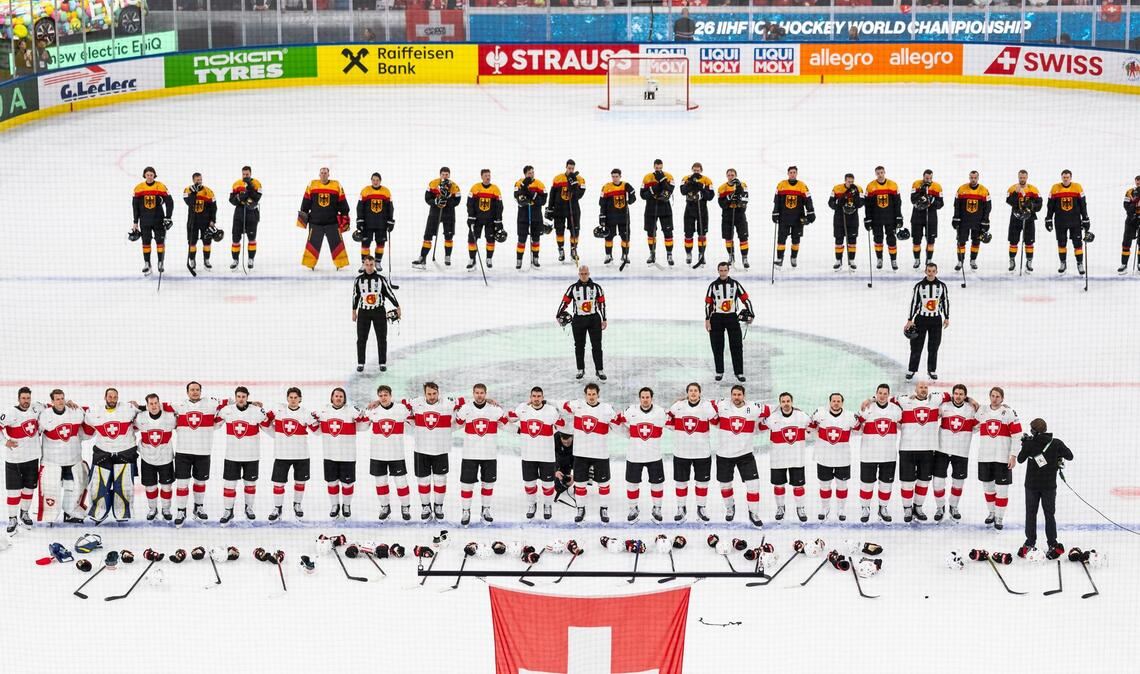 Die Schweizer (unten) und das deutsche Team steht auf dem Eis.