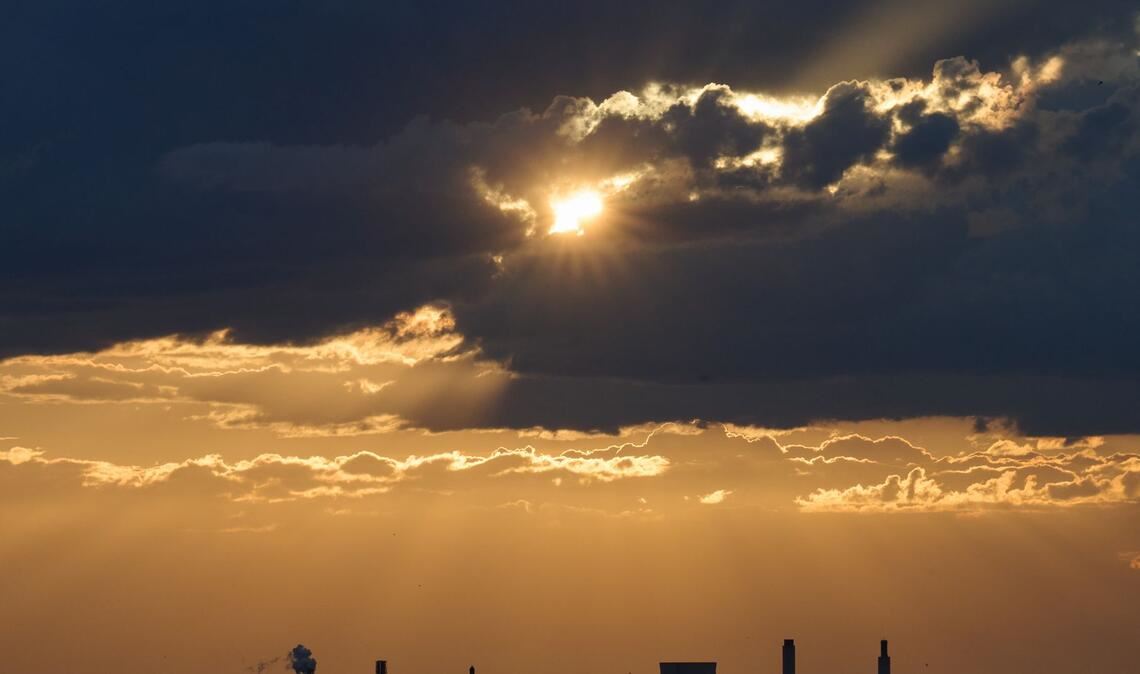 Die Sonne bricht über Berlin durch die Wolken.