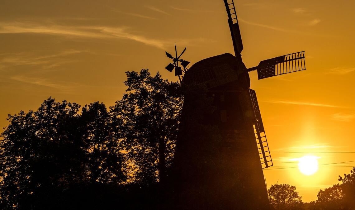 Die Sonne geht hinter der Turmholländermühle in Dörrwalde unter.