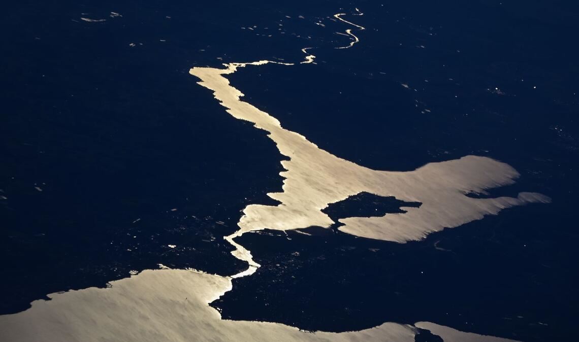 Die Sonne reflektiert sich im Bodensee, während die Stadt Konstanz, die Inseln Reichenau und Mainau sowie der Untersee und der Rhein zu sehen sind. (Aufnahme aus einem Flugzeug)