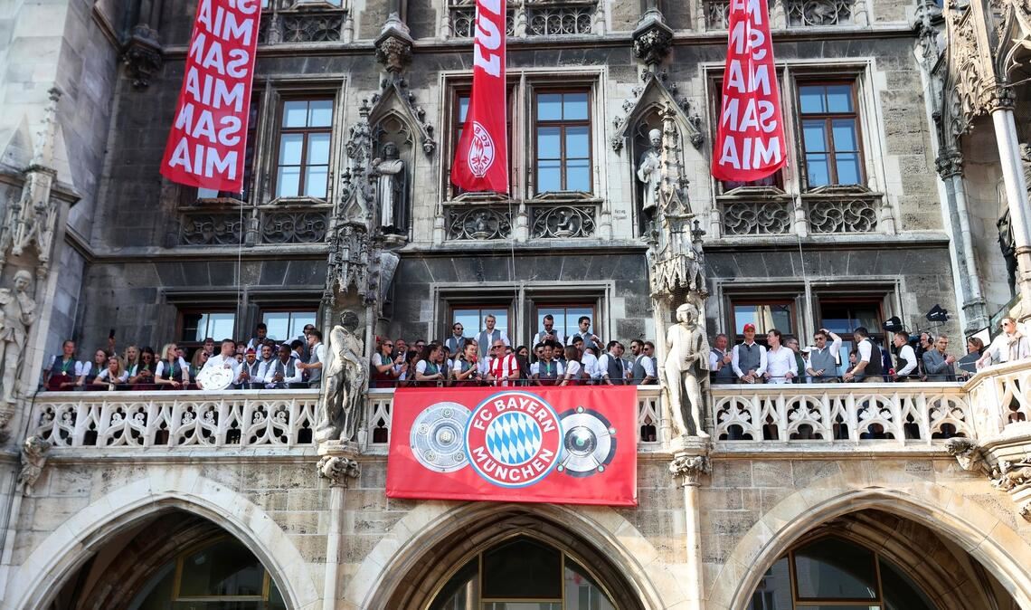 Die Spielerinnen und Spieler des FC Bayern feiern gemeinsam auf dem Rathaus-Balkon.