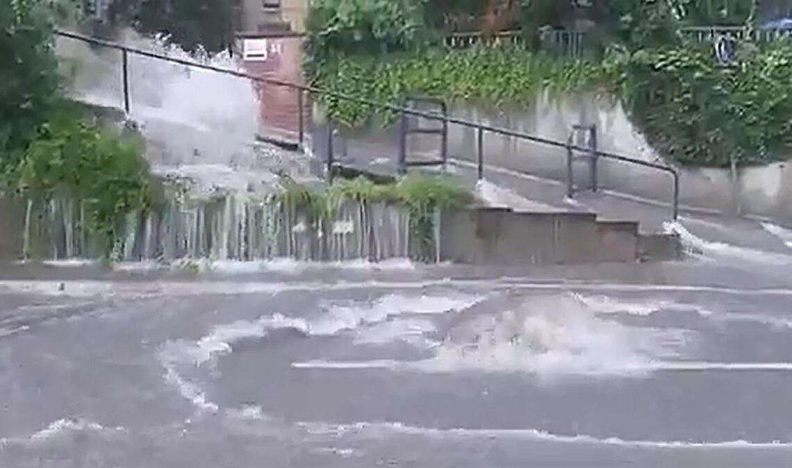 Die Szene aus einem privaten Handy-Video zeigt die Situation am Mittwochabend auf der Kieselbronner Straße in Enzberg, wo als Folge des Starkregens ein Sturzbach vom Hang strömt. Die Wassermassen drücken mehrere Gullydeckel aus der Fahrbahn. Ein Fahrzeug fährt in einen offenen Schacht und wird dadurch beschädigt.Foto: privat