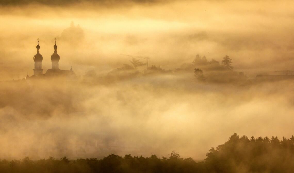 Die Türme St. Simon und Juda stehen im Morgennebel.