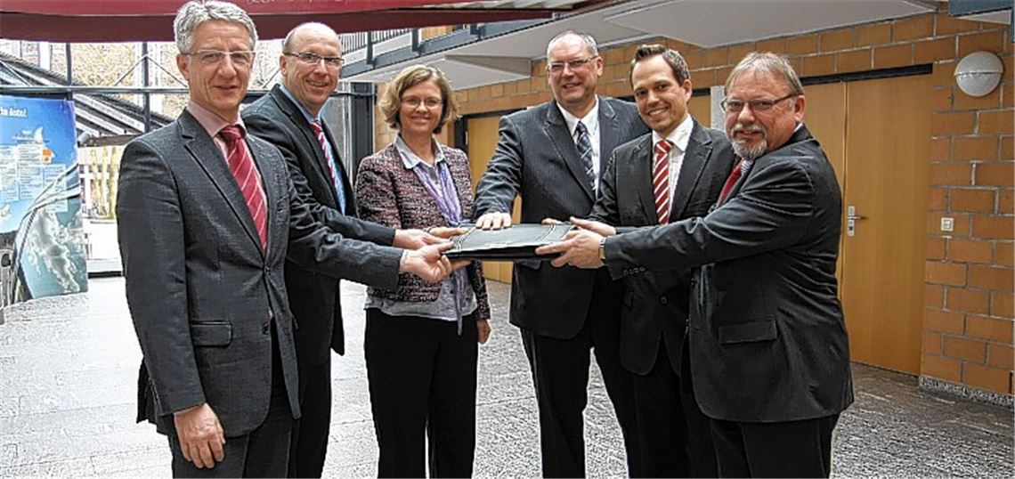 Die Vertreter der Organisatoren einer Gemeinschaftsveranstaltung zum Thema „Unternehmensnachfolge“ stellen die symbolische Übergabe[[br]]einer Firma dar. V. li.: Stefan Hammes (IHK), Jörg Fuchs (Handwerkskammer), Anette Popp (Wirtschaftsförderin der Stadt Mühlacker), Volker Kasper und Jochen Lewald (beide Sparkasse Pforzheim Calw) sowie Kurt Bickel (TeleGIS Sternenfels). 