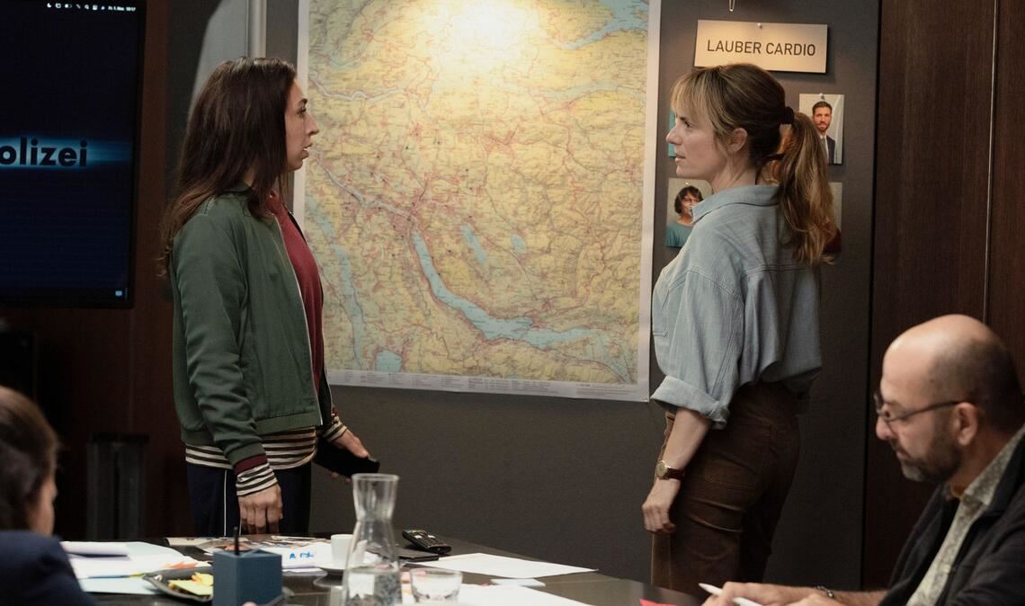 Die Zeit drängt im „Tatort – Kammerflimmern“ aus Zürich: Tessa Ott (Carol Schuler, li.) und Isabelle Grandjean (Anna Pieri Zuercher) vermerken auf einer Karte die Orte, an denen die Opfer starben.