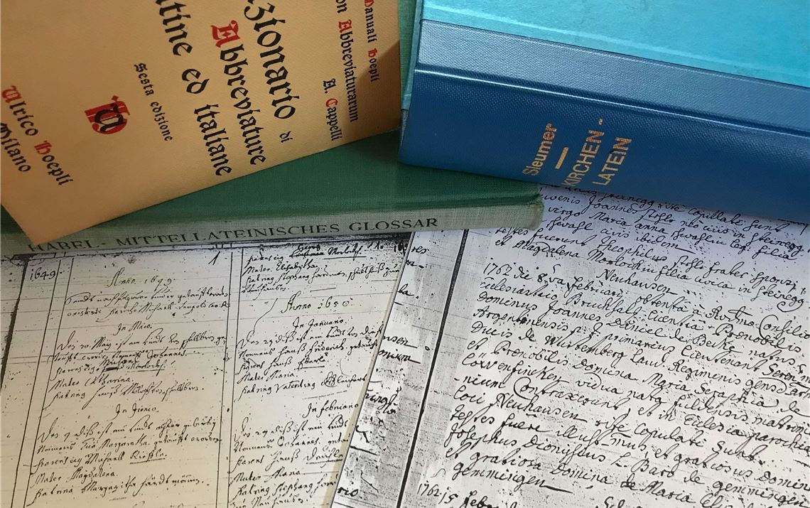 Die ältesten Taufeinträge aus dem Kirchenbuch Neuhausen, rechts der Heiratseintrag von Seraphia Schick, dahinter Hilfsmittel für die Recherchearbeit. Foto: Enzkreis/Volz