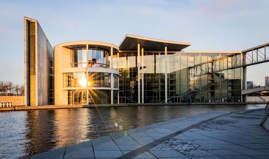 Die aufgehende Sonne spiegelt sich im Paul-Löbe-Haus des Deutschen Bundestag.