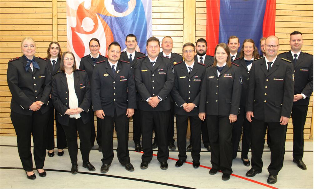 Die erste stellvertretende Kreisvorsitzende Stefanie Dörre (li.) ehrt mit dem Vorsitzenden des Feuerwehrverbandes Enzkreis, Kevin Rössle (re.), und Kreisbrandmeister Carsten Sorg (vorne, re.) zahlreiche Jugendleiterinnen und Jugendleiter. Foto: Prokoph