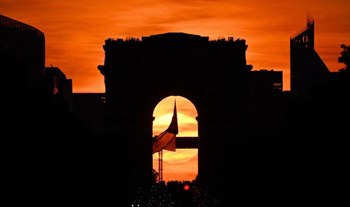 Die französische Nationalflagge weht unter dem Arc de Triomphe auf der Avenue des Champs Elysees während des sogenannten "Paris Henge"-Phänomens.