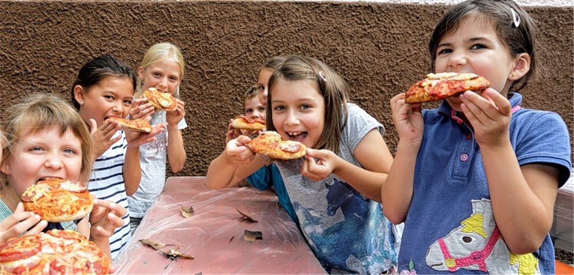 Die frische Pizza aus dem Backhaus schmeckt den Kindern sichtlich.Foto: Tilo Keller