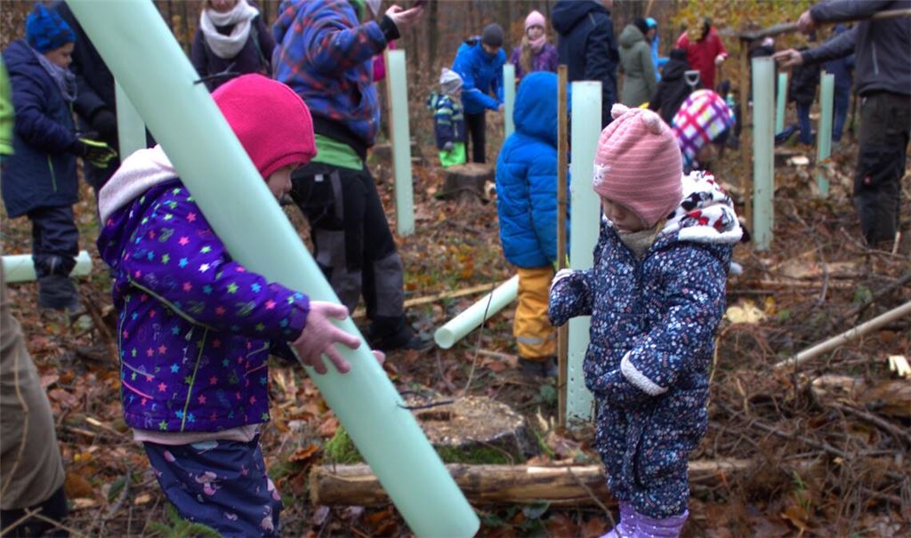 Die kleine Elena (links) stülpt den Schutz über den Setzling. Foto: Gießler