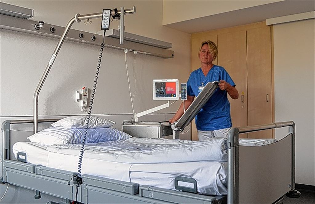 Die pflegerische Leiterin Christa Petri zeigt eines der neuen Patientenzimmer: Die modernen Betten sind unter anderem mit drehbaren Flachbildschirmen zum Fernsehschauen ausgestattet.