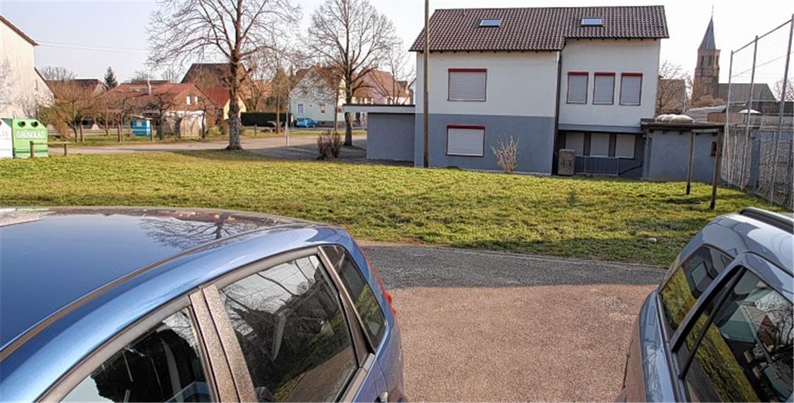 Diese Grünfläche zwischen der Turnhalle des TV Schmie und der Firma Renner wird schrumpfen. Dort wo sich jetzt ein Firmenparkplatz befindet, sollen künftig Lkw rollen. Dafür braucht die Firma einen Teil des Rasens, der bis jetzt auch vom Turnverein genutzt wurde.