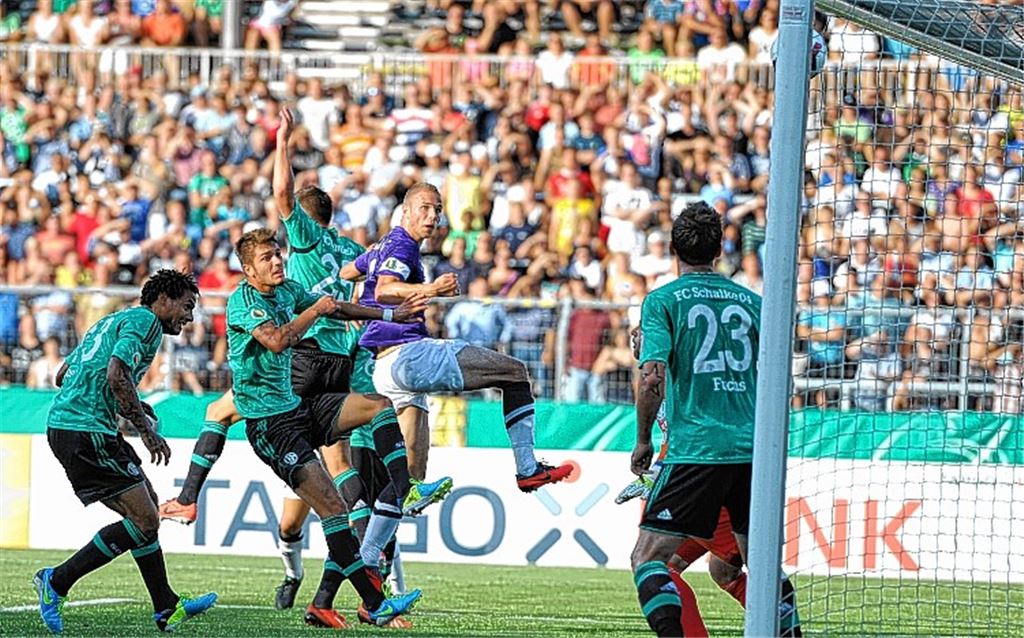 Diese Szene wird Holger Fuchs (lila Trikot) lange im Gedächtnis bleiben: Sein Kopfball in der 16. Minute klatscht an die Latte – der zweite Aluminiumtreffer des FC Nöttingen gegen Schalke. Foto: GES-Sportfoto