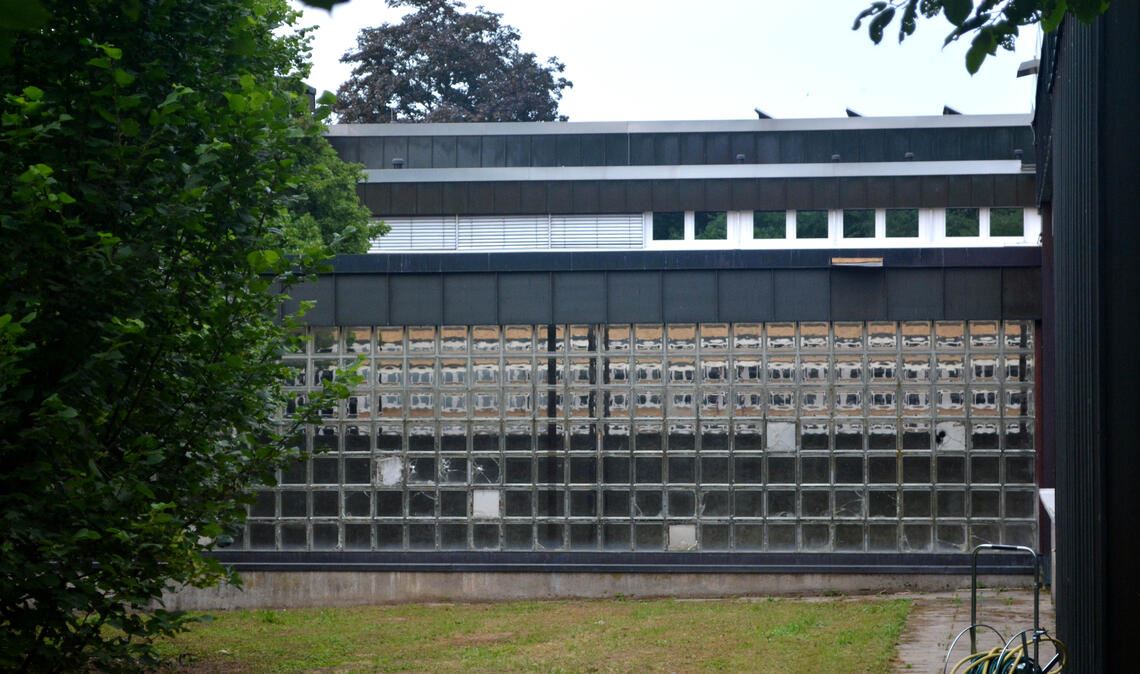Diese Wand aus Glasbausteinen wird entfernt, damit die Schülerinnen und Schüler Zugang zum hinteren Schulhofbereich haben. Foto: Stahlfeld