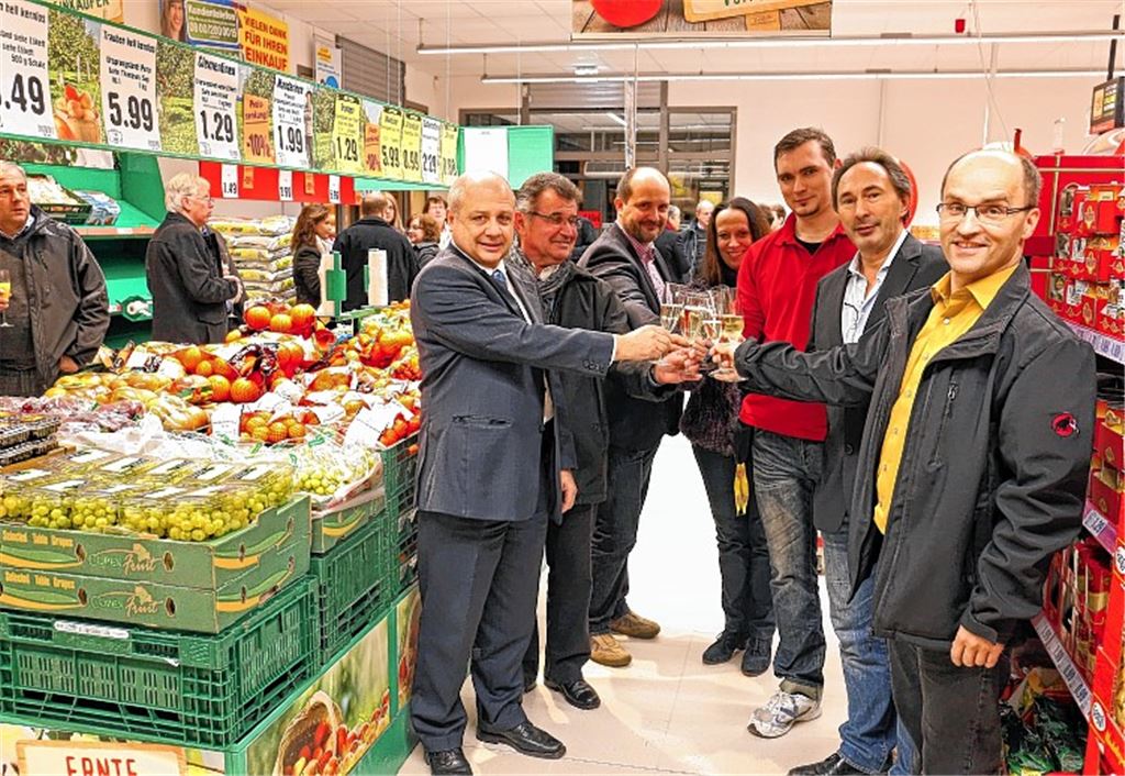 Dieter Glöckner (li.), Gebietsleiter Expansion bei Netto, Bürgermeister Harald Eiberger (re.), Illinger Gemeinderäte und Mitarbeiter des Netto-Markts stoßen auf die Neueröffnung an.