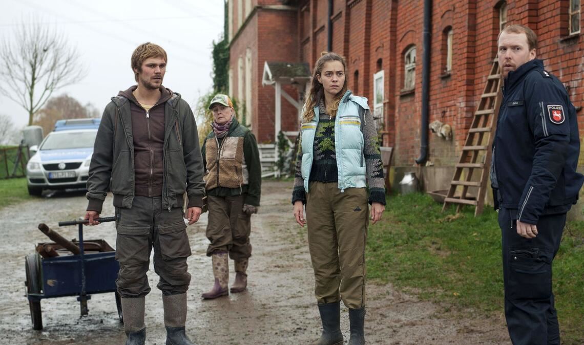 Doch kein Unfall? In der Scheune finden sich Hinweise auf Vertuschung (v. l. n. r.: Sven Feldhusen (Henning Flüsloh), Marlies Feldhusen (Lina Wendel), Frauke (Ronja Herberich), Polizist Olaf Gehrke (Ole Fischer)).