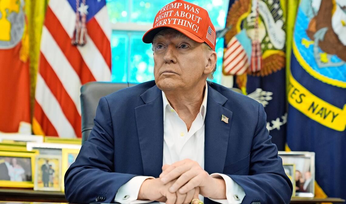 Donald Trump an seinem Schreibtisch im Weißen Haus: Er trägt eine Kappe mit der Aufschrift: „Trump hatte in allem recht!"