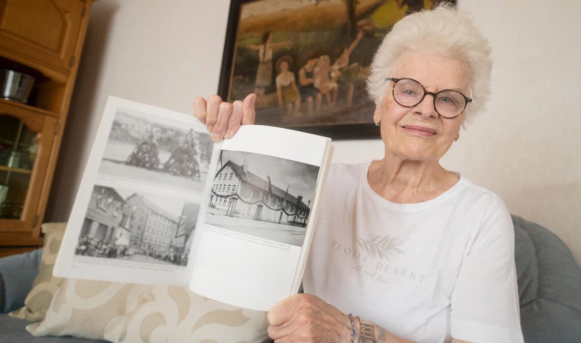 Doris Gerlach betrachtet in Marlies Schäfer-Gollnows Buch, das Archivbilder aus Mühlacker zeigt, ein Foto der ursprünglichen Käppele-Turnhalle. Diese wurde vor 90 Jahren für den schnell wachsenden Turnverein gebaut und 1937 in Zeiten der Naziherrschaft bei einem Kreissportfest offiziell eingeweiht. Foto: Fotomoment