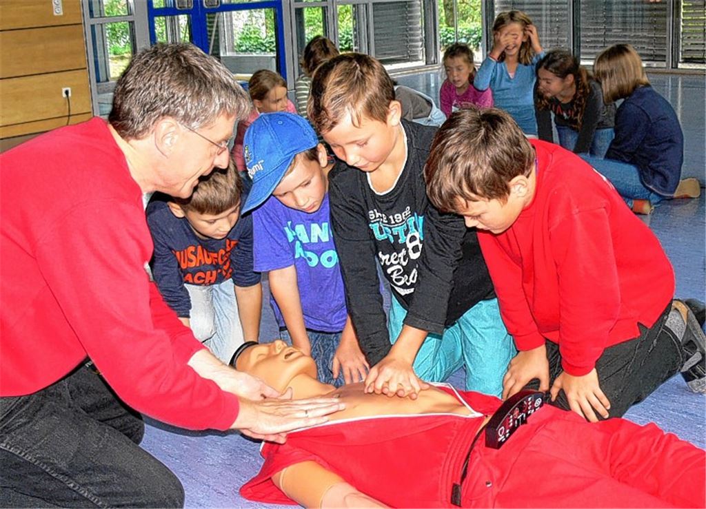 Dr. Stefan Bosch zeigt den Viertklässlern die richtigen Handgriffe im Notfall.