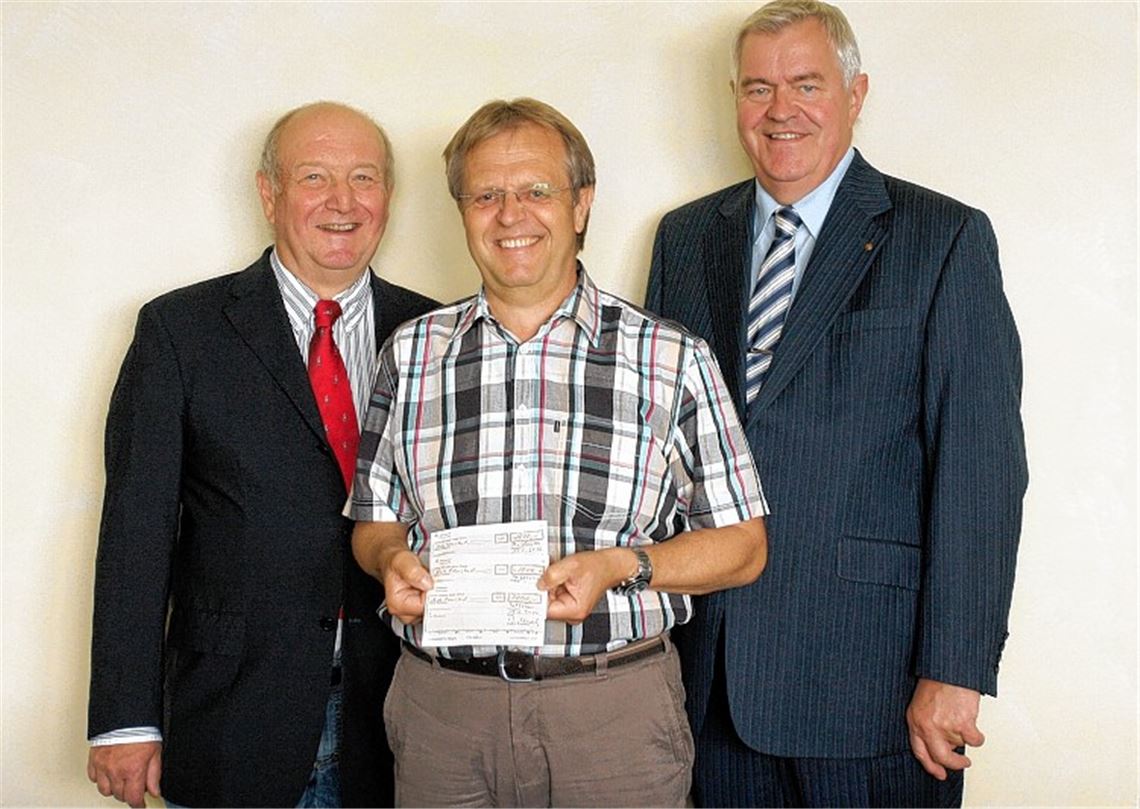 Dr. Wolf-Dieter Weschler, Präsident des Rotary Clubs Mühlacker-Enzkreis (li.), und Rotarier Wolfgang Hofmann (re.) übergeben Schultes Werner Henle Spendenschecks für Hochwasseropfer.