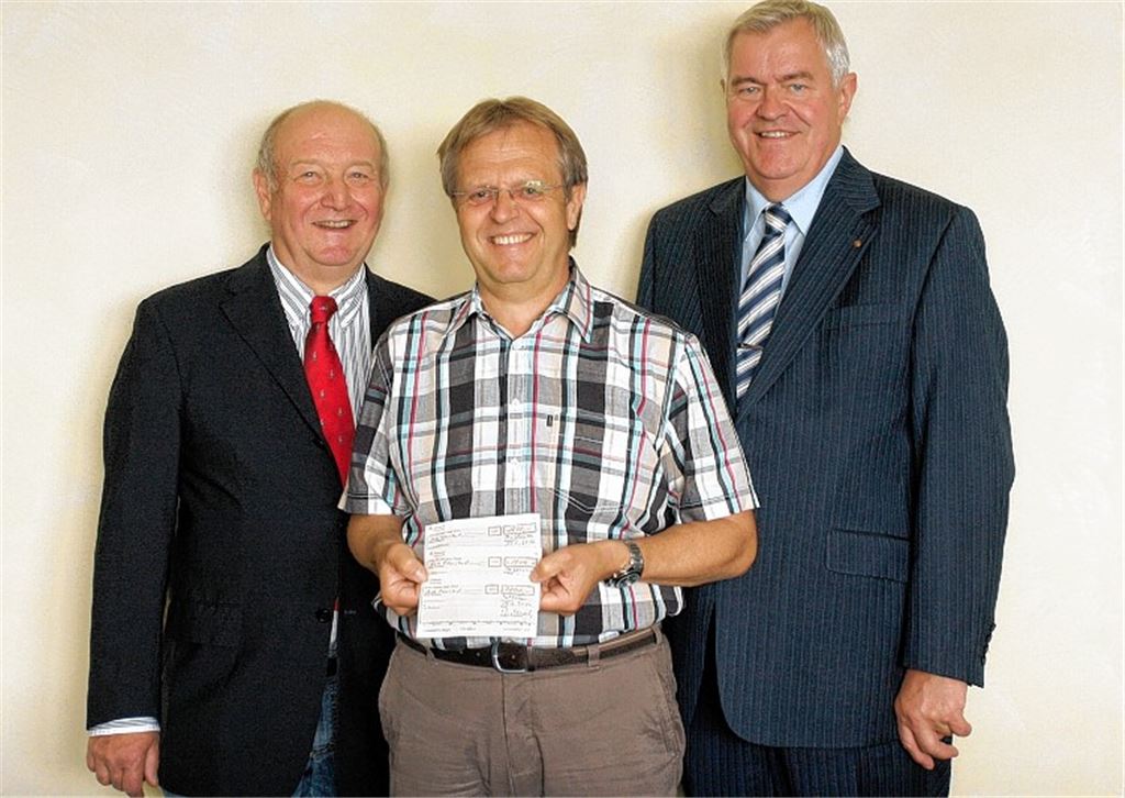 Dr. Wolf-Dieter Weschler, Präsident des Rotary Clubs Mühlacker-Enzkreis (li.), und Rotarier Wolfgang Hofmann (re.) übergeben Schultes Werner Henle Spendenschecks für Hochwasseropfer.