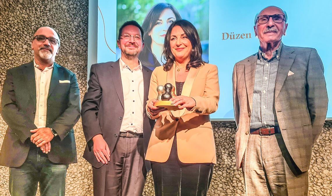 „Tief bewegt von der Liebe im Raum“ Düzen Tekkal mit (v.li.) ihrem Bruder, dem Laudator Michael Blume und ihrem Vater. Foto: Metzbaur