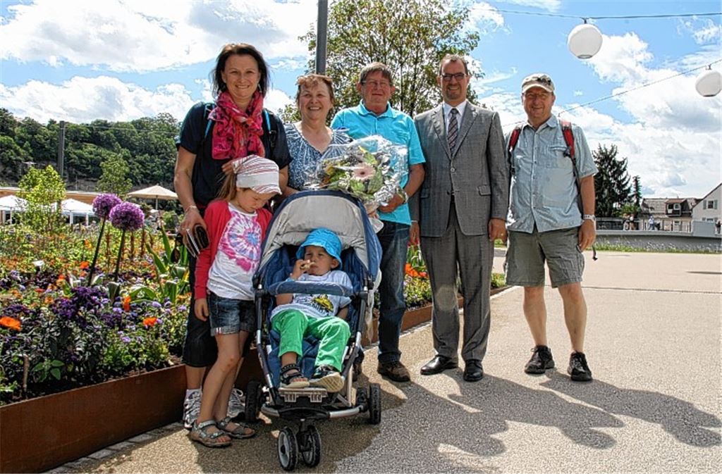 Edith Trost im Kreis ihrer Familie, nachdem sie von OB Frank Schneider (2.v.re.) als 100000. Besucherin mit einem Blumenstrauß und einem Gartenschauwein überrascht worden ist.