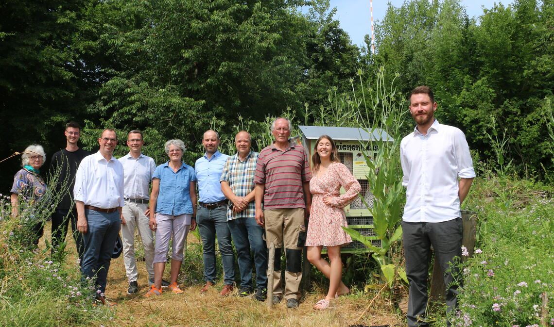Ehrenamtliche Schafferinnen und Schaffer um Werner Hofmeister (3.v.re.), Sponsoren und Unterstützer sowie Oberbürgermeister Frank Schneider (3.v.li.) freuen sich über das Biotop am Klotzberg in Lomersheim neben dem Friedhof St. Peter. Unter den Insekten hat sich bereits herumgesprochen, dass es hier viel zu holen gibt. Fotos: Disselhoff