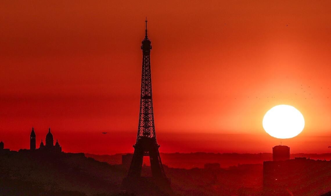 Eiffelturm und der Basilika Sacre Coeur auf dem Montmartre-Hügel, während in der Stadt im Sommer 2025 wegen der hohen Temperaturen Alarmstufe Rot herrscht.