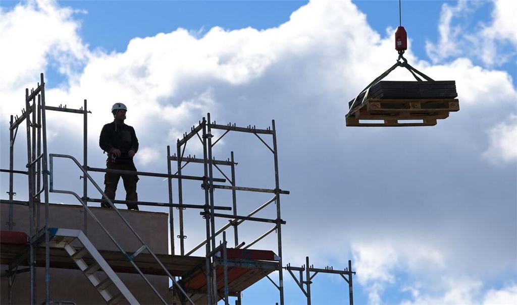 Ein Arbeiter dirigiert auf einer Baustelle einen Kran. Das Wirtschaftswachstum in Deutschland nimmt laut Bundesbank im Frühjahr leicht zu. Aber dann?