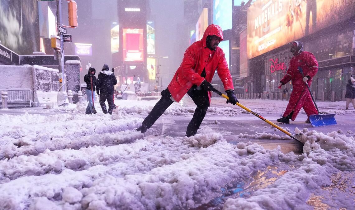 Ein Arbeiter schaufelt Schnee auf dem Times Square in New York. Ein heftiger Schneesturm zieht über den Nordosten der USA hinweg.