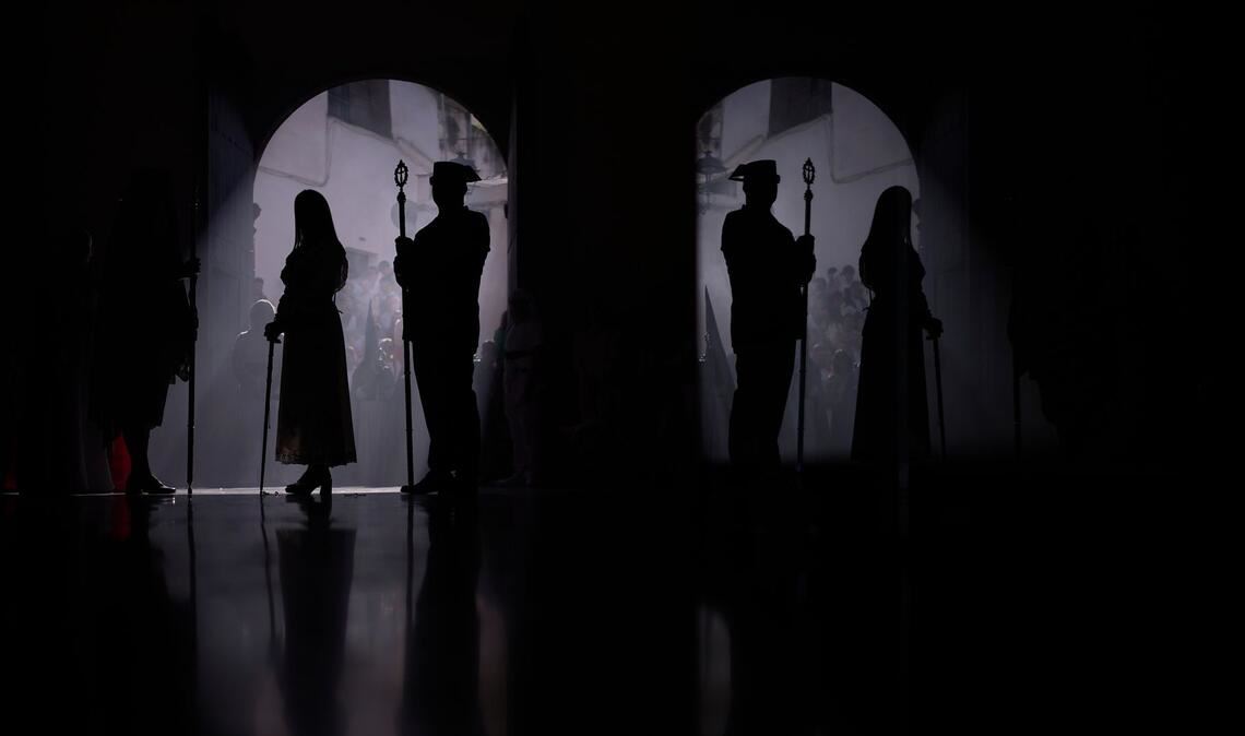 Ein Beamter der Guardia Civil (r) und ein Büßer nehmen an einer Prozession teil.