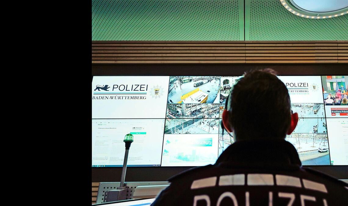Ein Beamter steht im Führungs- und Lagezentrum des Polizeipräsidiums Mannheim vor einer Wand mit Bildschirmen. (Symbolfoto)