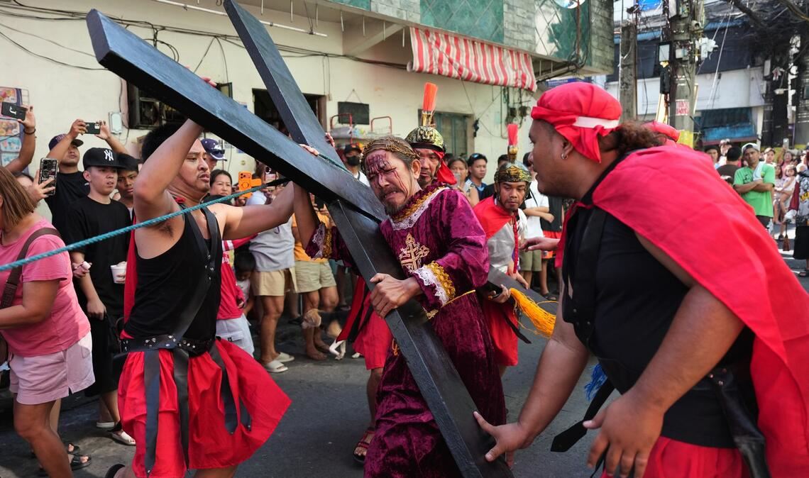 Ein Büßer mit einem Holzkreuz während eines Passionsspiels in Mandaluyong, das die Leiden Jesu Christi nachstellt. Die Szene spielt am Gründonnerstag im Rahmen der Karwochen-Feierlichkeiten.