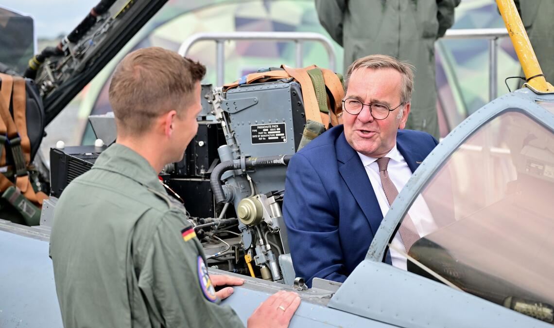 Ein Bundeswehr-Soldat zeigt dem Minister auf der ILA einen Tornado-Simulator.