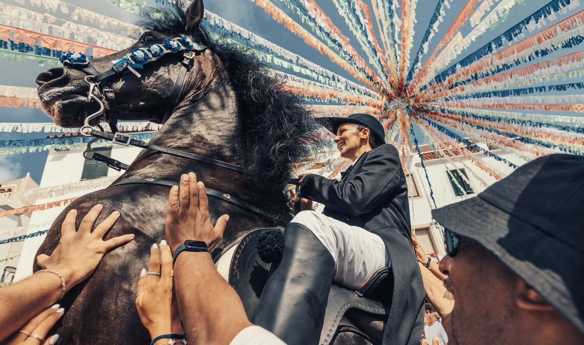 Ein "Caixer" zäumt sein Pferd inmitten einer jubelnden Menge während des traditionellen "Jaleo" bei dem Sant Bartomeu Fest in Spanien.